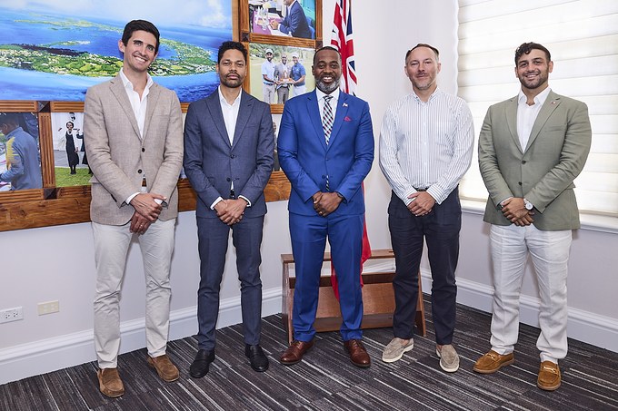 Five attendees standing together in front of a Bermuda flag